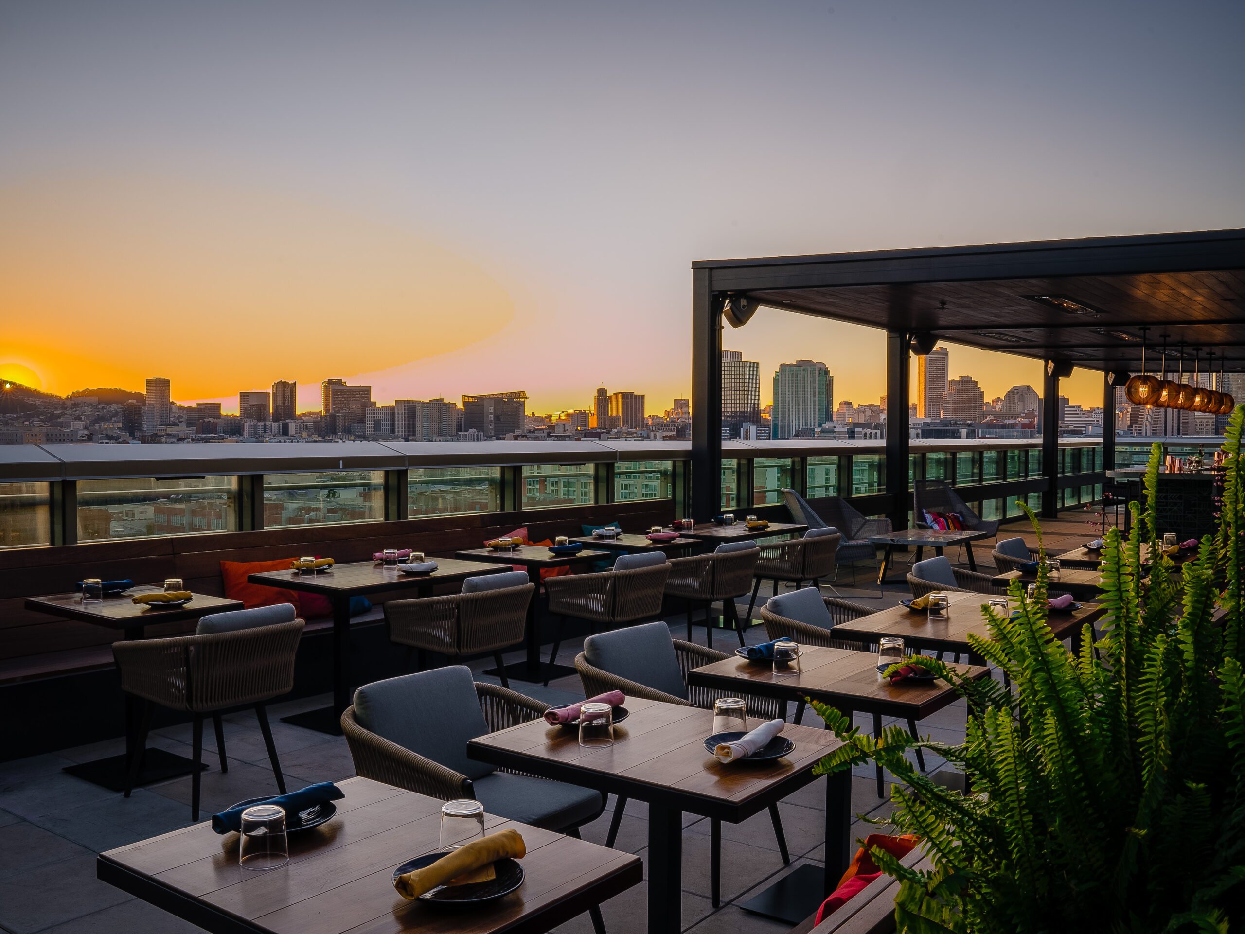 Restaurant table and chairs on the Kaiyo Rooftop San Francisco CA at dusk